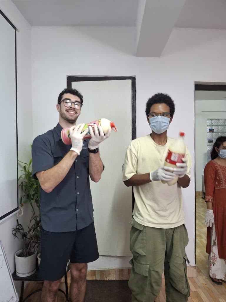 Two people wearing gloves holding freshly made bars of handmade soap
