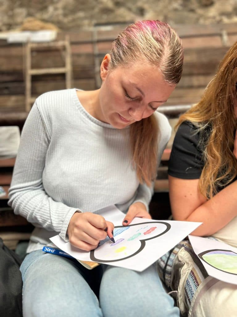 A participant colouring a printed wellbeing worksheet during a group session