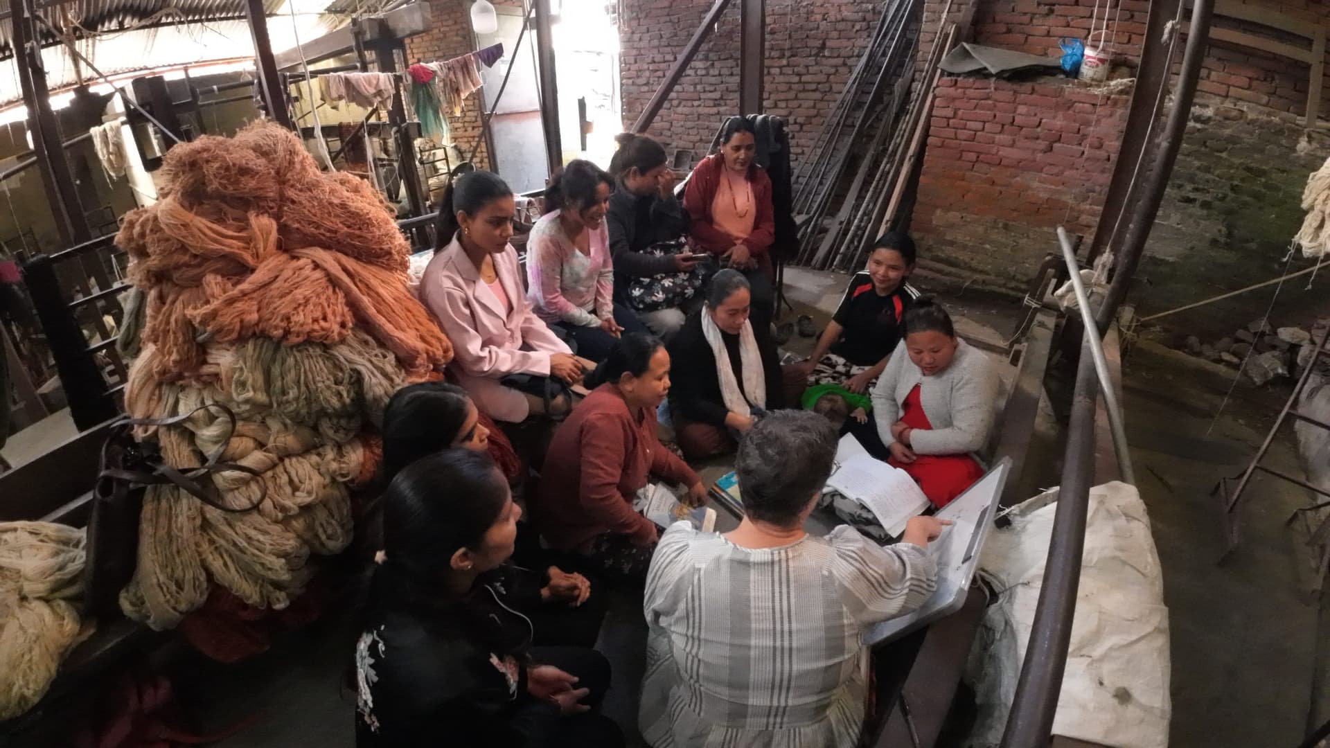 Women seated in a circle with a facilitator during a group session inside a community workspace